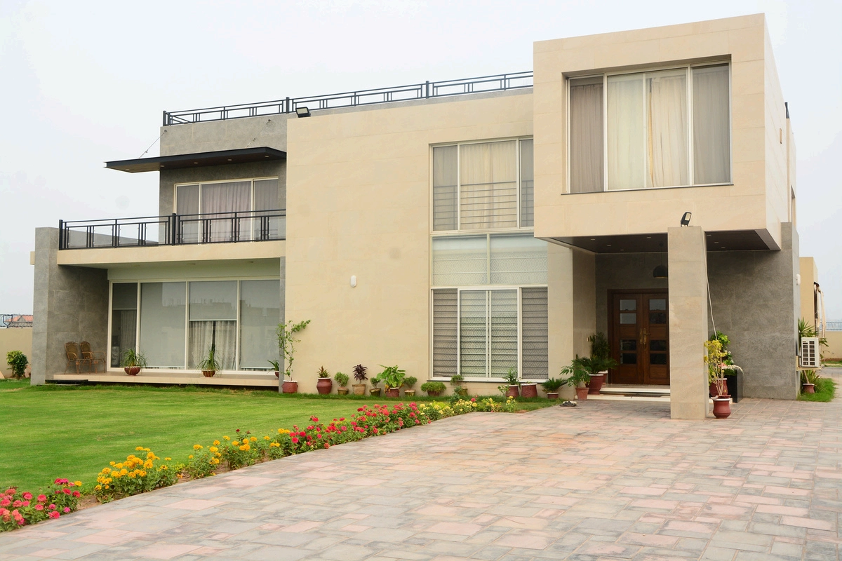 Perspective view of the Arif Zaman House showing the expansive lawn, paved driveway, and contemporary facade design.