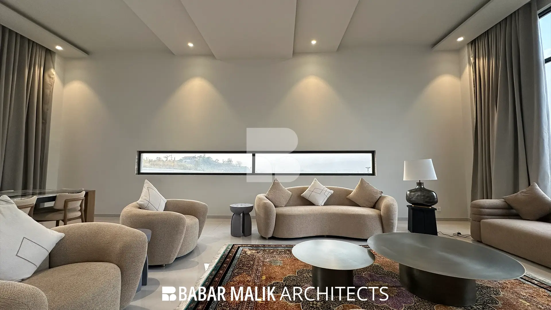 Side perspective of the formal drawing room, highlighting the curved furniture arrangement, metallic coffee tables, and a horizontal slit window integrated into the wall design.
